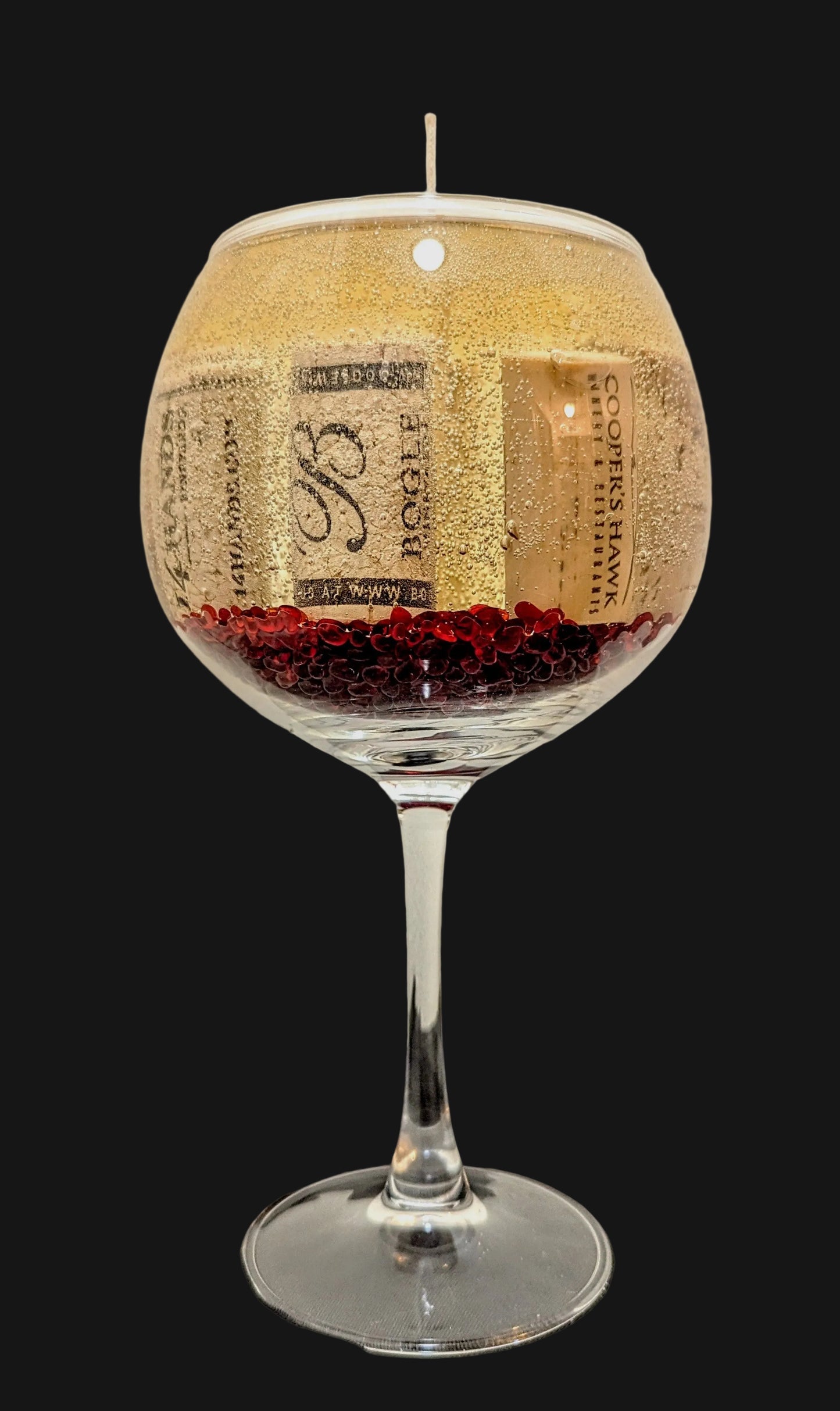 Wine glass with red glass beads and corks